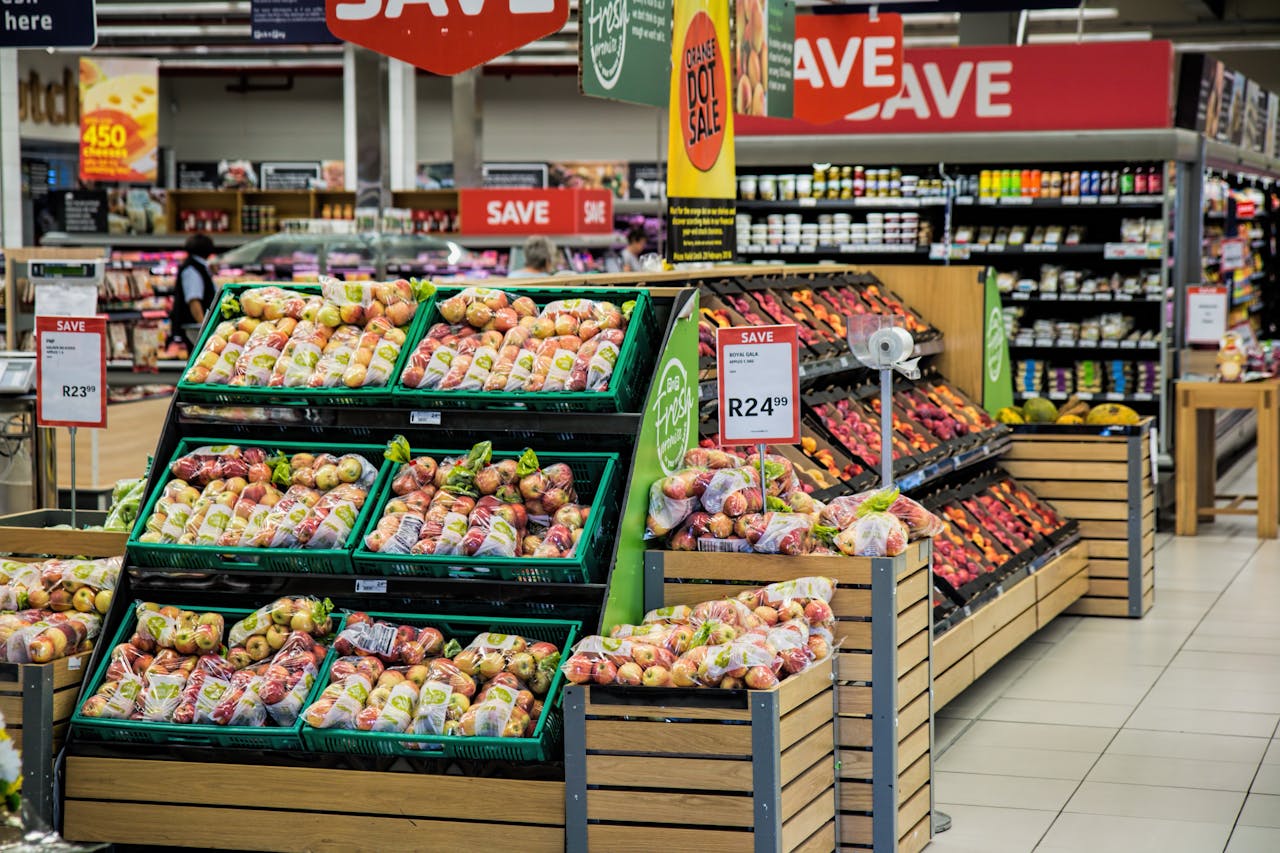 services-01 Colorful produce aisle in a supermarket showcasing fresh apples with discount signage.