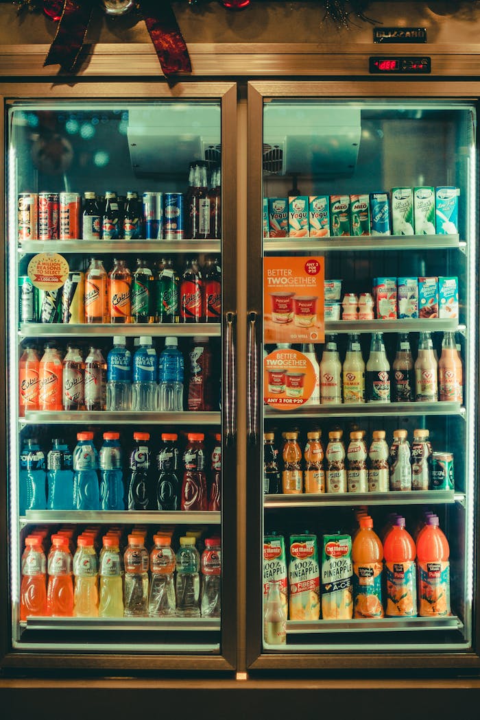 who-we-are Assorted chilled beverages displayed in a store refrigerator showcasing various drink options for sale.